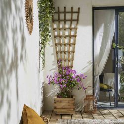 Treillis SEVILLA mis en situation sur un mur avec un pot au pied pour que la plante grimpante puisse s'accrocher