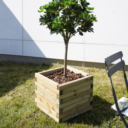Bac à fleurs carré en bois rempli de terreaux et d'un arbuste à côté d'une chaise dans un jardin 
