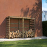 Abri-bûches COLOMBUS XL en ambiance dans un jardin, contre un mur avec des bûches entreposées à l'intérieur