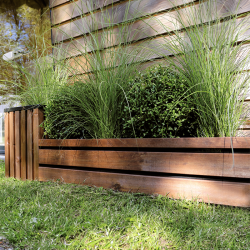 Bordure en bois LIGN Z mise en situation dans un jardin délimitant la pelouse d'un massif de plantes