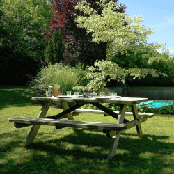 Table de pique-nique ROBUSTE en situation dans un jardin, au bord d'une piscine avec la table dressée