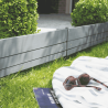 Bordure NOVA mise en situation dans un jardin délimitant la pelouse de quelques arbustes et lasuré en gris