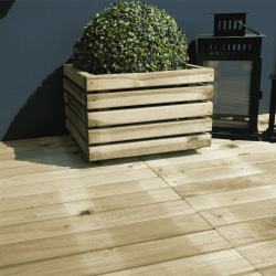 Dalle 50x50 à lames rainurées produit mis en situation en extérieur avec un bac à fleurs dessus