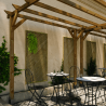 Treillis CLEMATITE 90cm en situation, fixé contre un mur sous une pergola sur une terrasse de restaurant, avec du lierre dessus