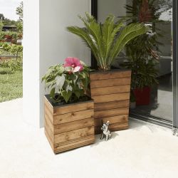 Bac à fleurs en V COLLECTORS en situation sur une terrasse blanche, avec un bac à fleurs de la même collection version carré