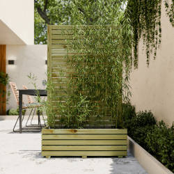 Bac à fleurs occultant KUB, mis en situation sur une terrasse, servant de séparation entre une zone repas et une zone détente