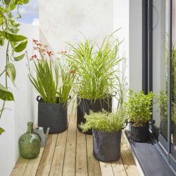 Plusieurs sacs de plantation en feutre géotextile Gris Anthracite en ambiance sur un balcon