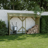 Abri-bûches MEMPHIS XL en ambiance dans un jardin, contre un mur avec des bûches et une brouette entreposées à l'intérieur